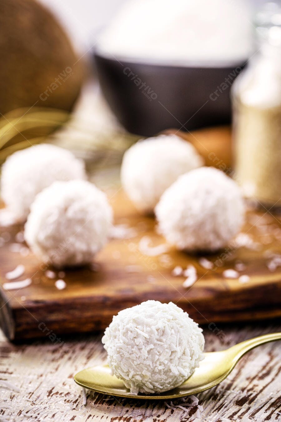 Beijinho doce de coco branco na colher dourada com ingredientes