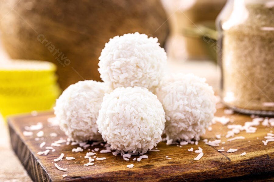 Brigadeiro de coco branco beijinhos em tábua de madeira rústica