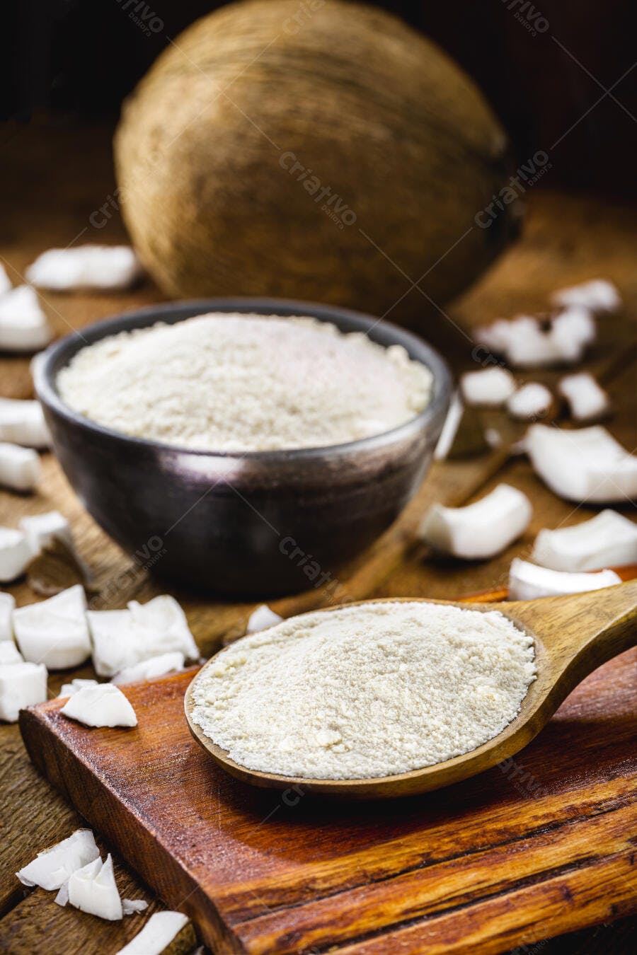 Farinha de coco orgânica em colher de pau e tigela escura