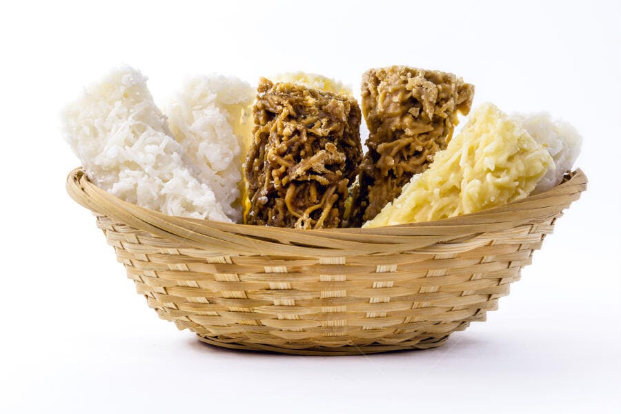 Cocadas doces brasileiras em cesta de palha com variações brancas e morenas