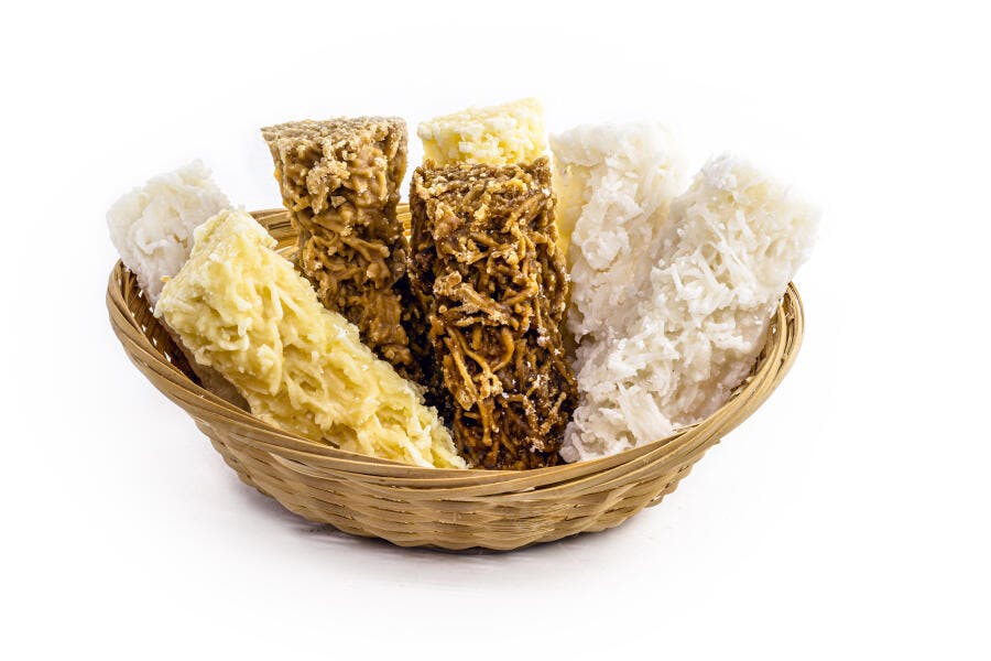 Cesta de cocadas brancas marrons e amarelas artesanais em estúdio branco