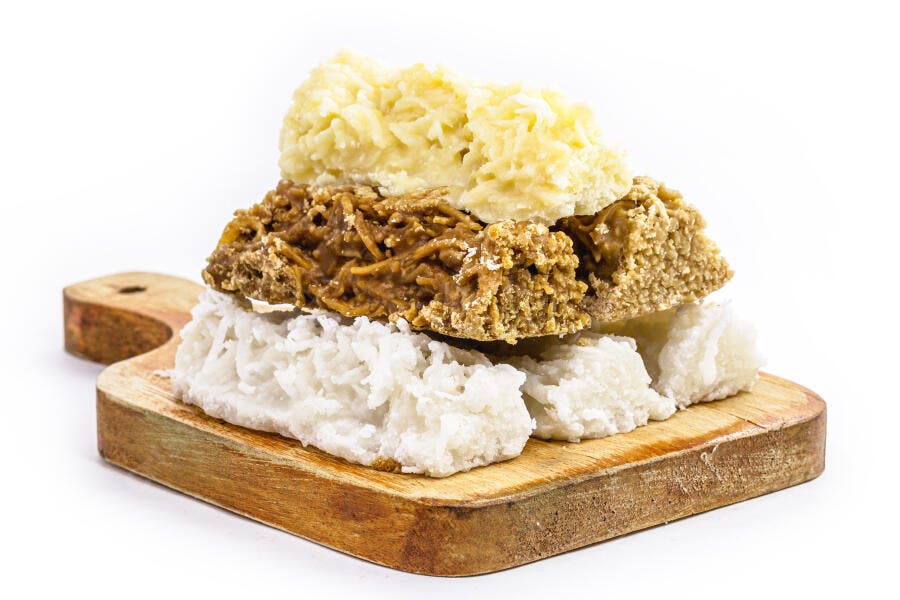 Cocadas brasileiras variadas empilhadas em tábua de madeira rústica