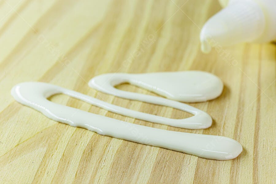 Creme branco viscoso espalhado sobre tábua de madeira clara