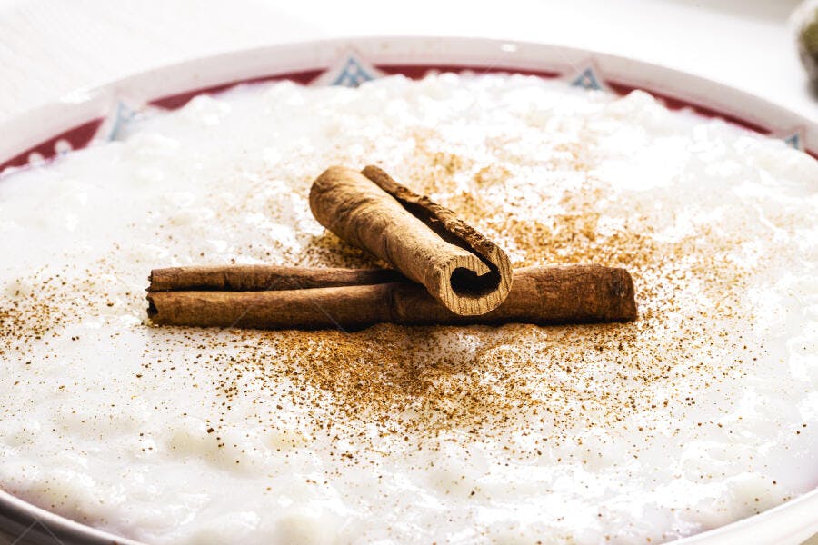 Arroz doce cremoso com canela em pó e pau de canela