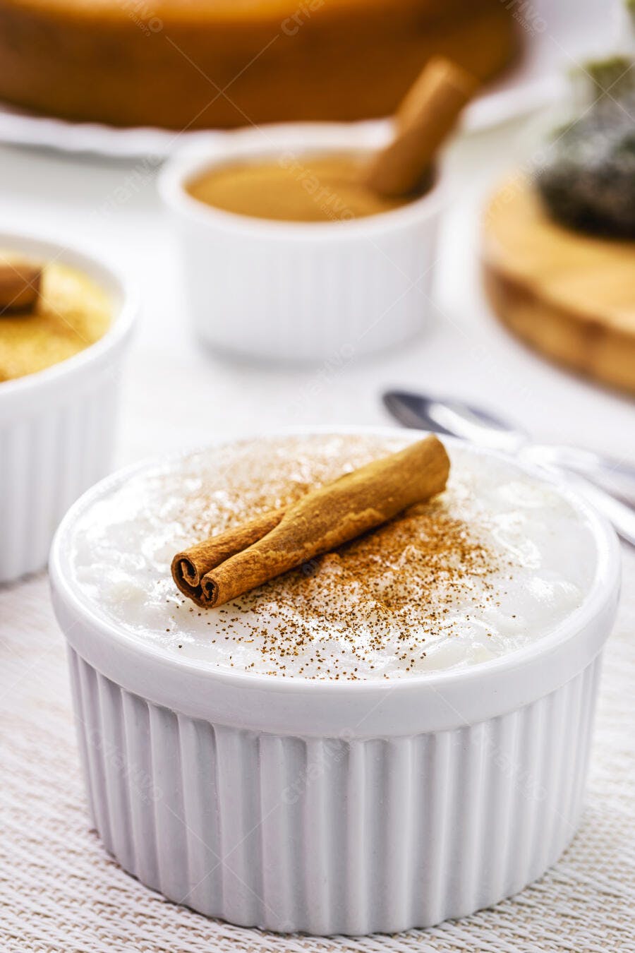 Arroz doce cremoso com canela em pau e pó em tigela branca