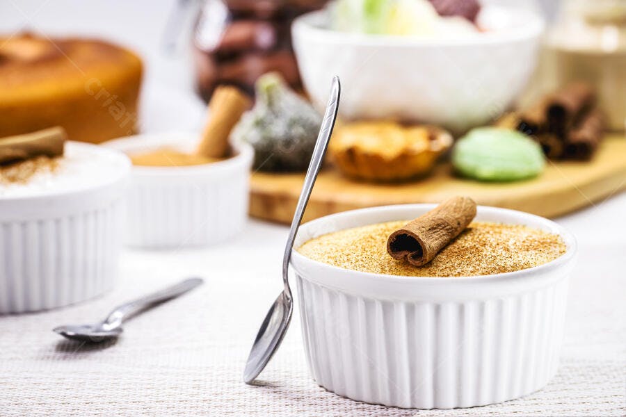 Doce cremoso com canela em ramekin branco e colher de prata