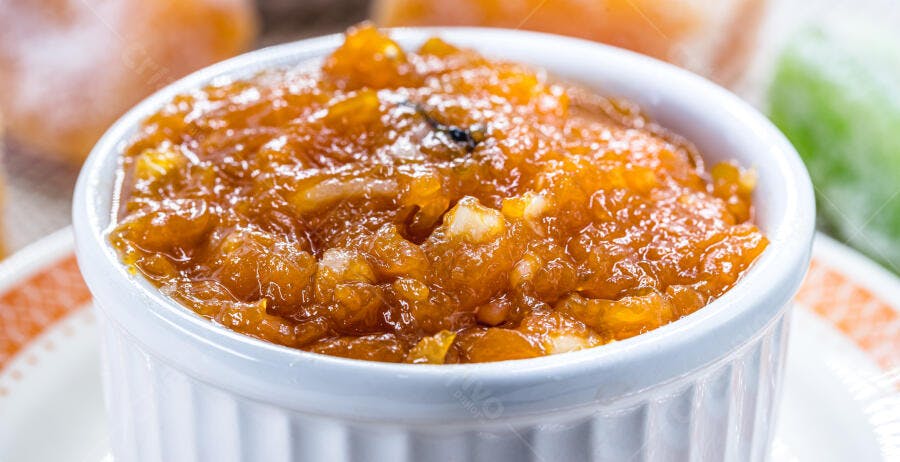 Doce de mamão caseiro em tigela branca com frutas cristalizadas