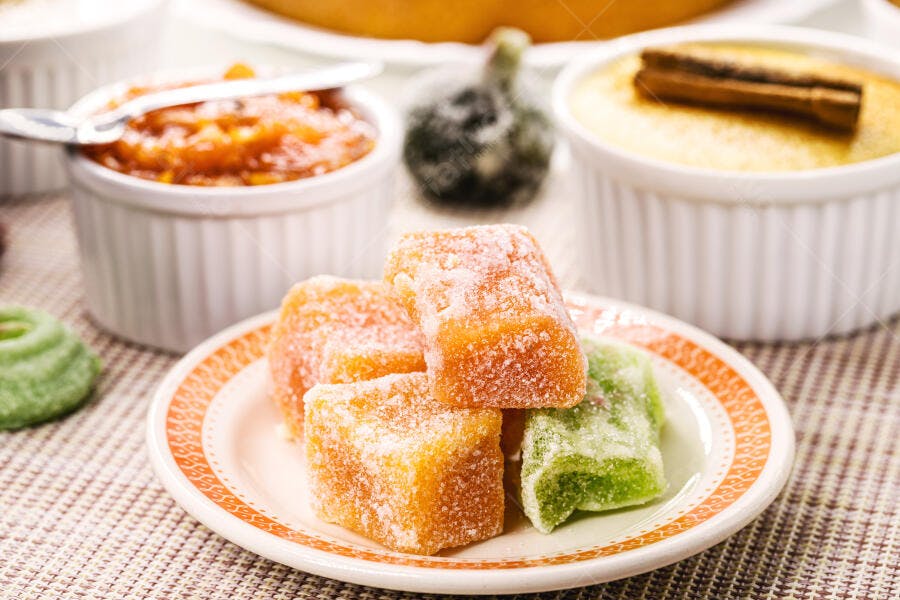 Doces cristalizados laranja e verde em mesa de sobremesas tradicionais brasileiras