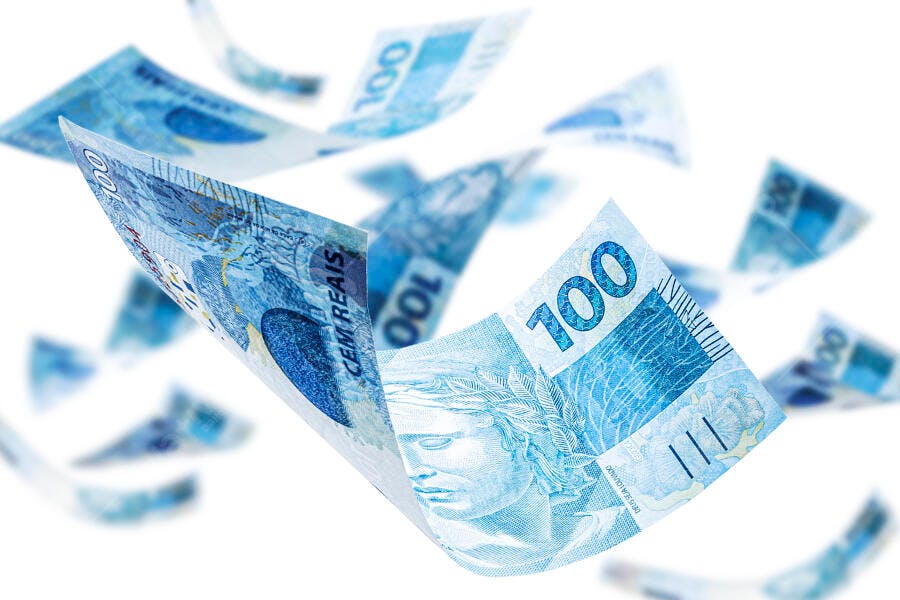 Notas de cem reais azuis caindo em fundo branco economia brasileira