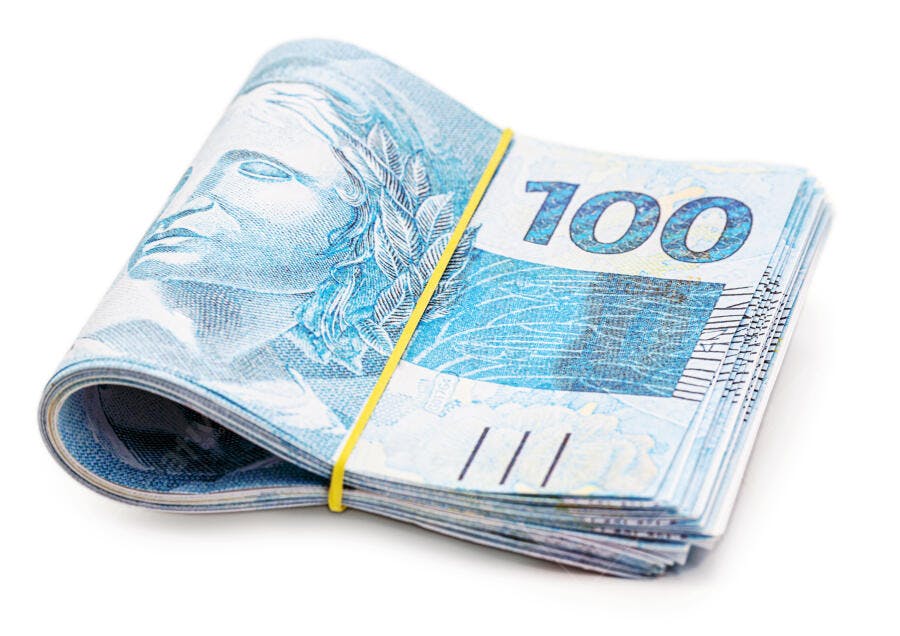 Cédulas azuis de 100 Reais brasileiras dobradas em fundo branco
