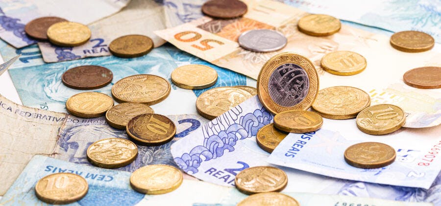 Dinheiro brasileiro notas e moedas de real espalhadas valor financeiro