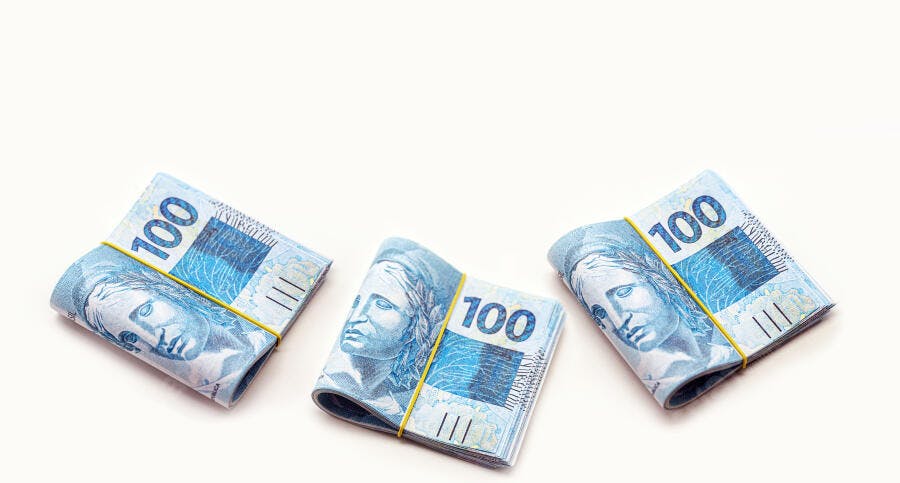 Cédulas de 100 Reais empilhadas dinheiro brasileiro em fundo branco