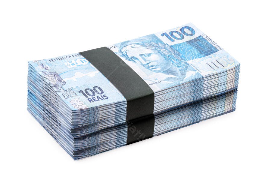 Cédulas de 100 Reais empilhadas com elástico em fundo branco