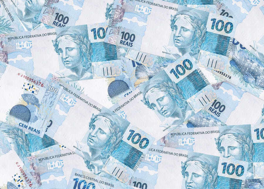 Cédulas de 100 e 10 Reais brasileiras espalhadas fundo de dinheiro