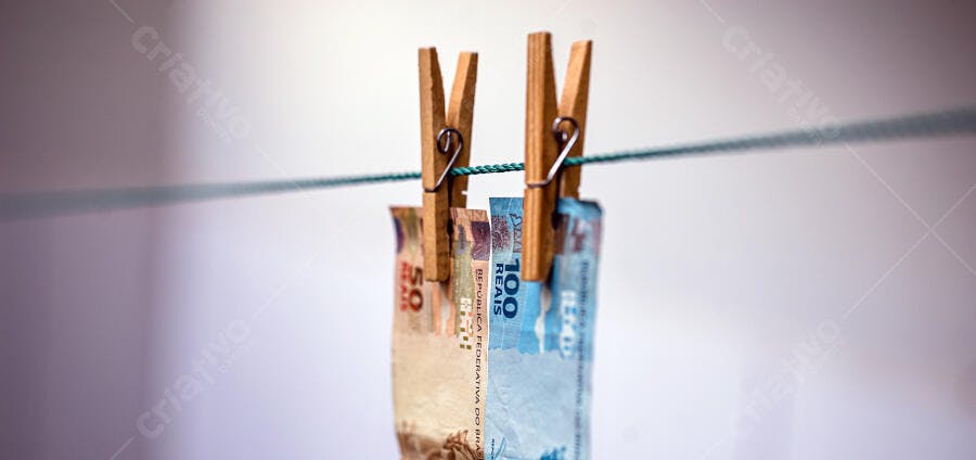 Dinheiro brasileiro notas de reais secando no varal com prendedores de roupa