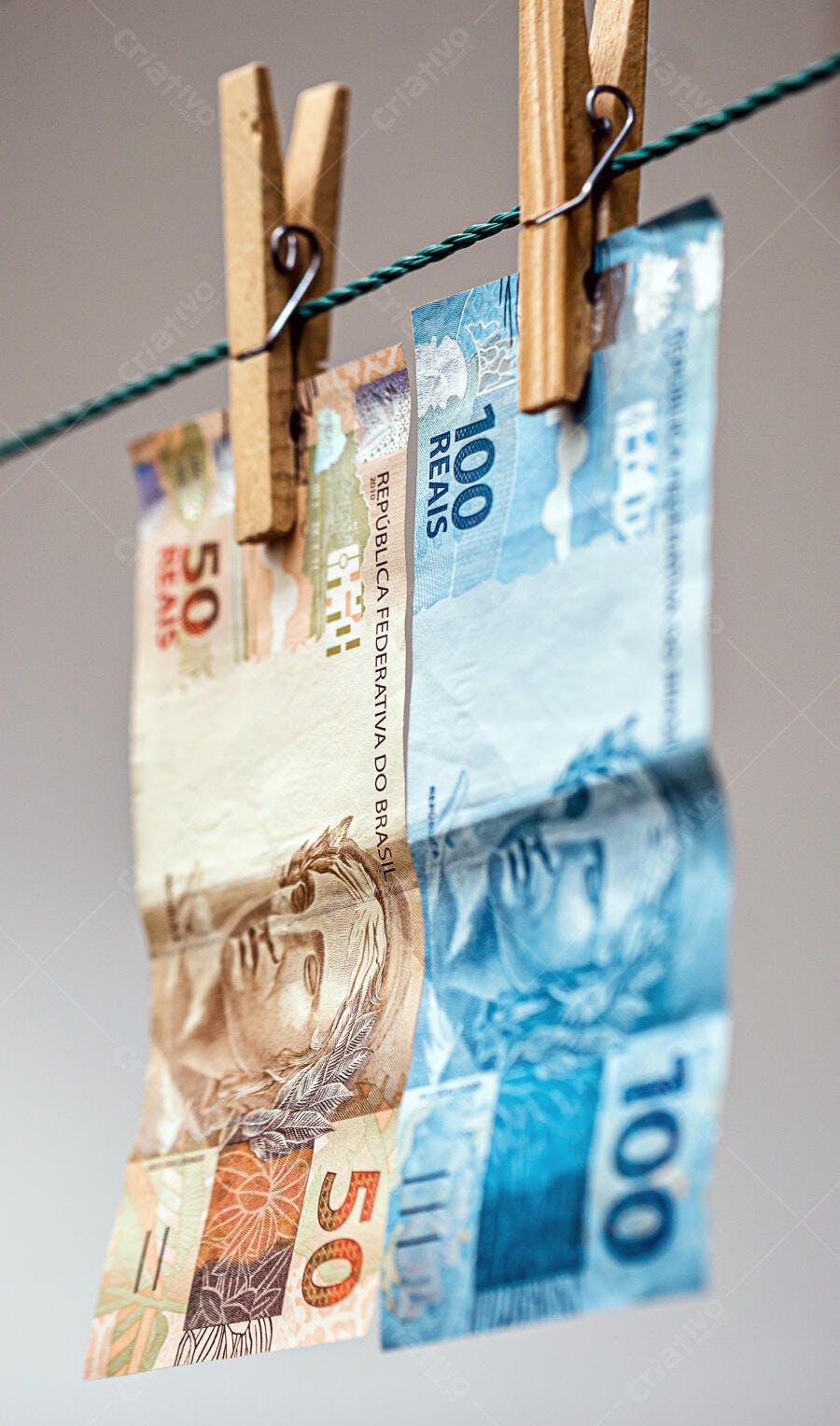 Cédulas de Reais brasileiras penduradas no varal com prendedores de madeira