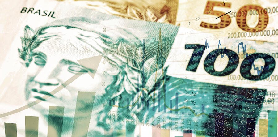 Moeda brasileira Real com gráficos financeiros de crescimento econômico