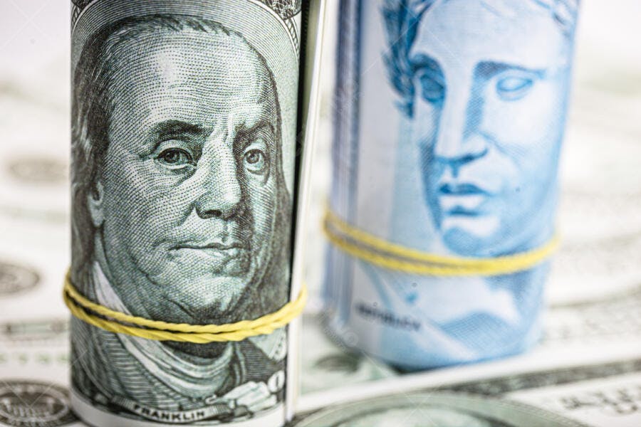 Dinheiro dólar americano e real brasileiro rolos com elástico amarelo