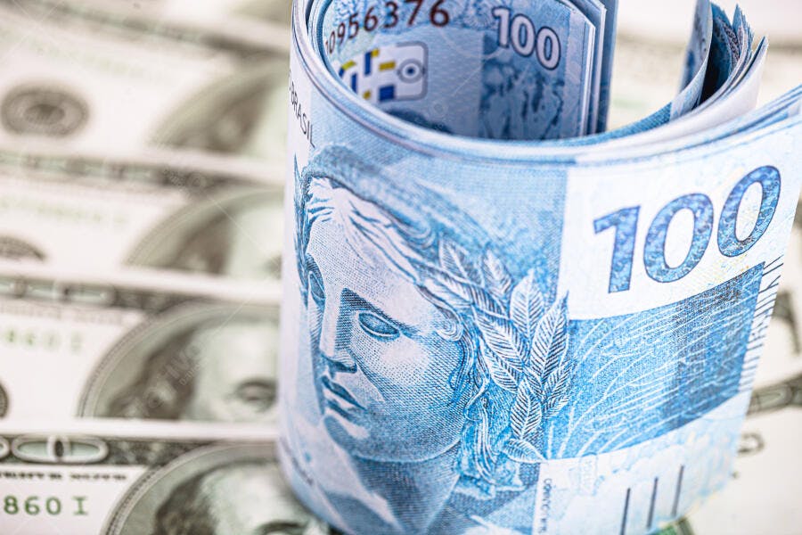 Cem reais enrolados sobre notas de dólar americano símbolo de economia global