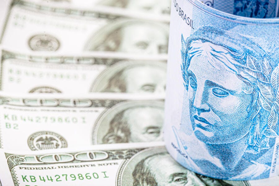 Cédulas de real e dólar americano juntas em contraste financeiro global
