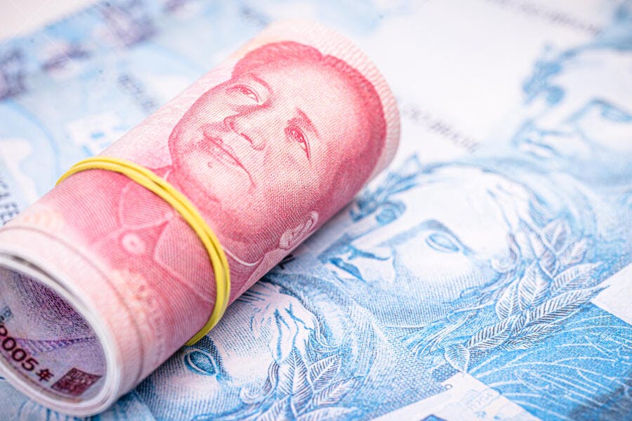 Notas de Yuan chinês enroladas com borracha sobre dinheiro Real brasileiro