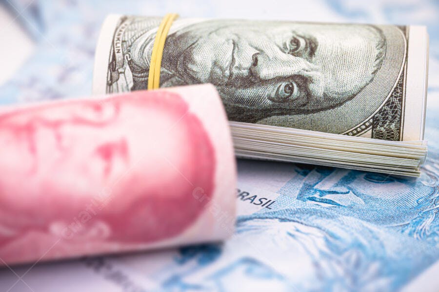 Dinheiro dólar americano enrolado com yuan e real brasileiro