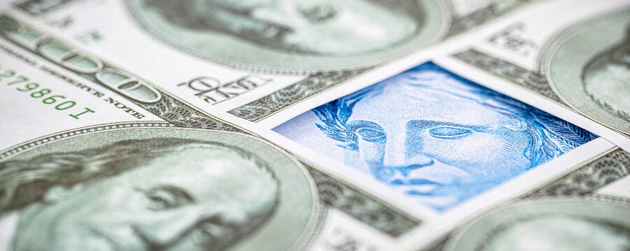Dólar americano e Real brasileiro notas com face azul da República em close-up