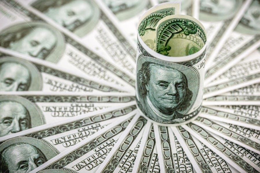 Cédulas de cem dólares enroladas e espalhadas dinheiro americano economia