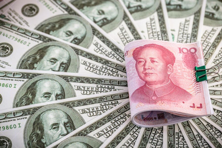 Cédulas de dólar e yuan com clipe verde economia global finanças