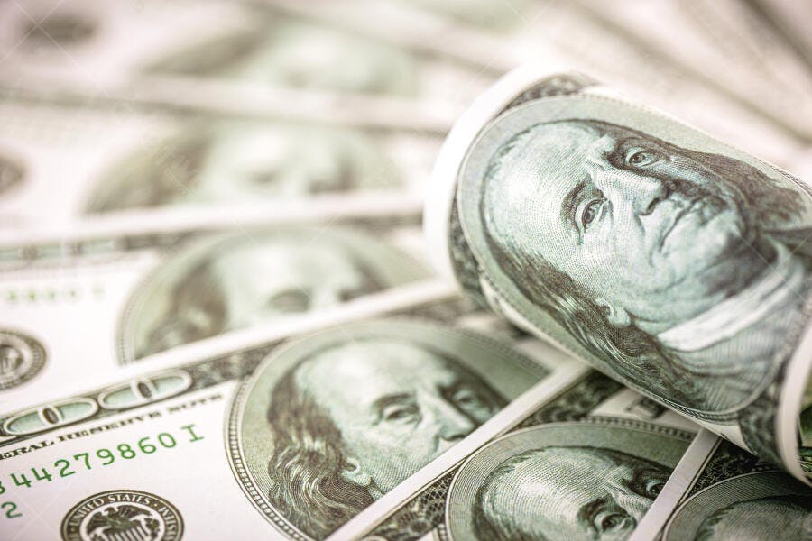 Notas de cem dólares americanas empilhadas e enroladas close-up