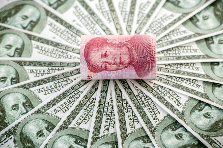 Cédula de Yuan chinês sobre dólares americanos arranjados em leque