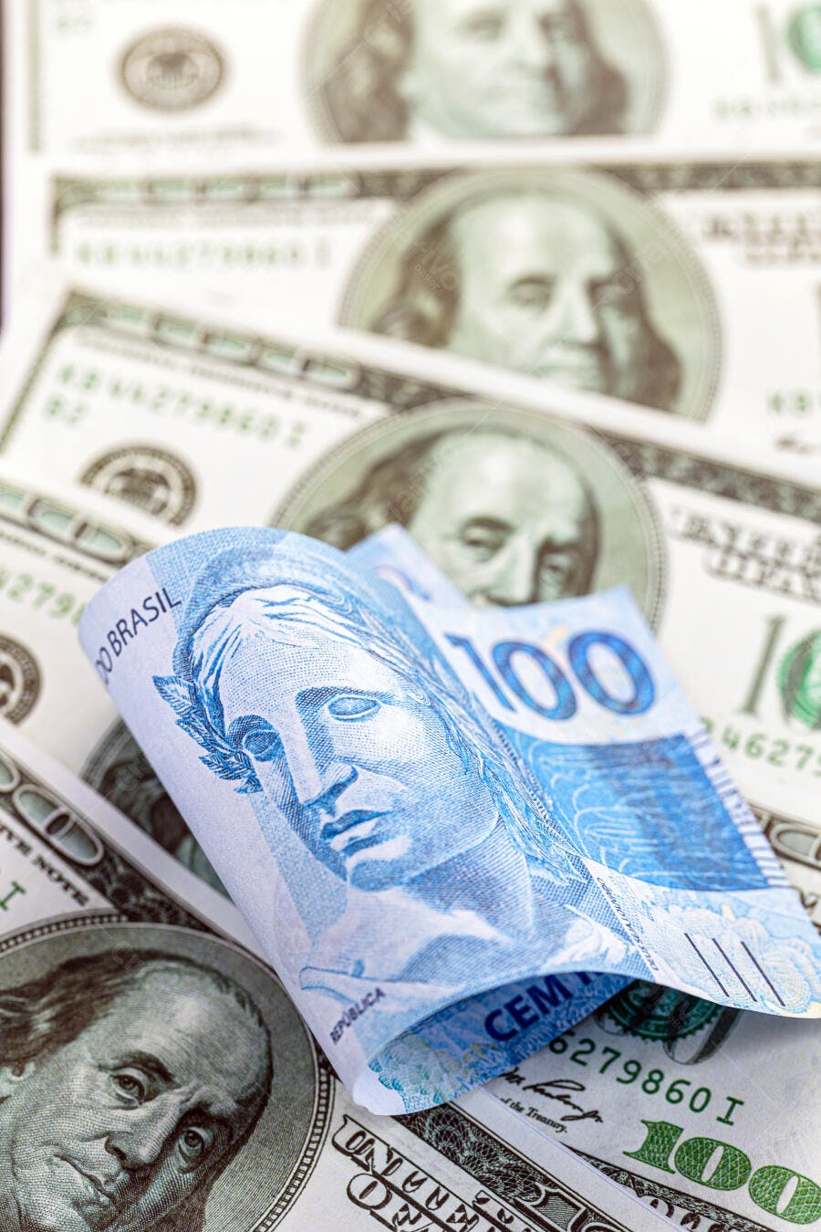 Nota de 100 Reais azul sobre 100 Dólares americanos verdes economia global