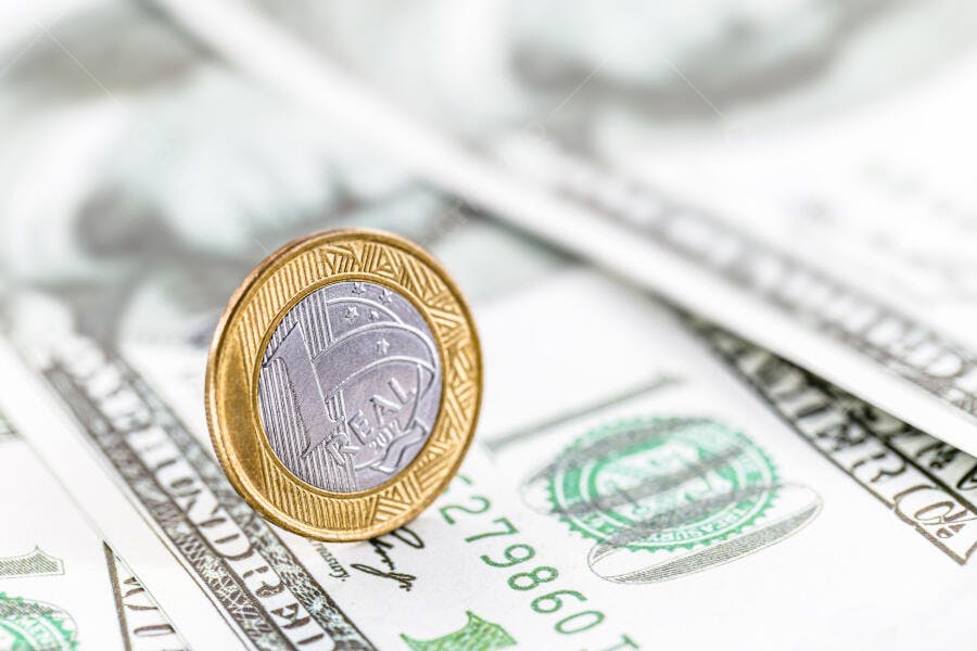 Moeda Real brasileiro em notas de dólar americano economia global