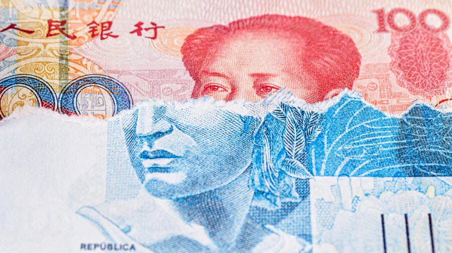 Moedas chinesa e brasileira rasgadas sobrepostas retrato de Mao Zedong e República