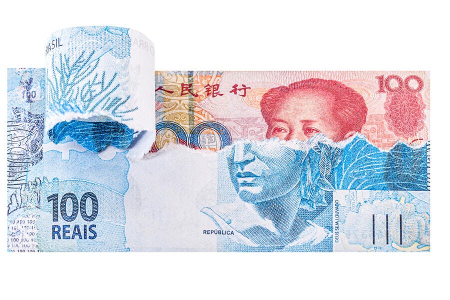 Notas de 100 reais e yuan rasgadas em fundo branco conceito financeiro