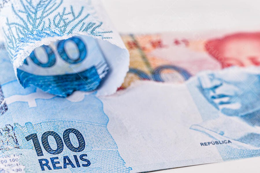 Notas de 100 Reais brasileiras azuis enroladas close-up de finanças e economia
