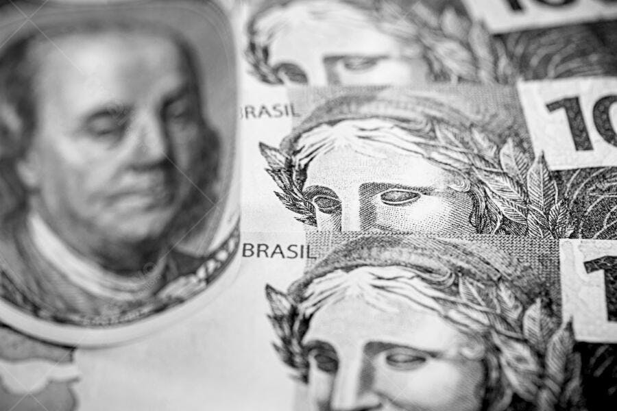 Cédulas de Real brasileiro e Dólar americano em close-up preto e branco