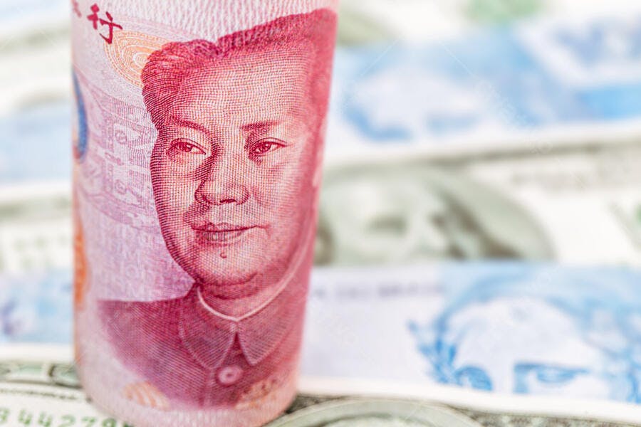 Nota de 100 Yuan chinesa enrolada com Mao Zedong e dólares americanos no fundo