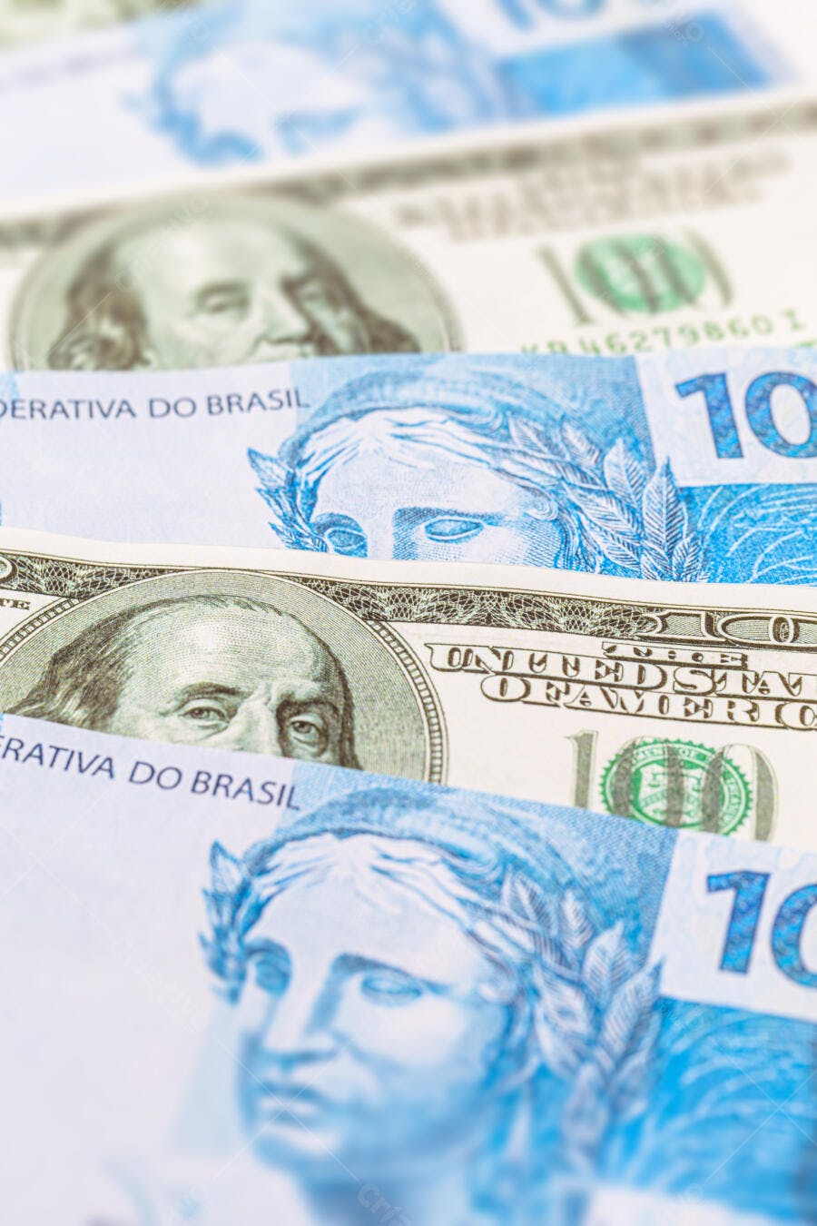 Cédulas de Real e Dólar azul e verde em close-up com Benjamin Franklin