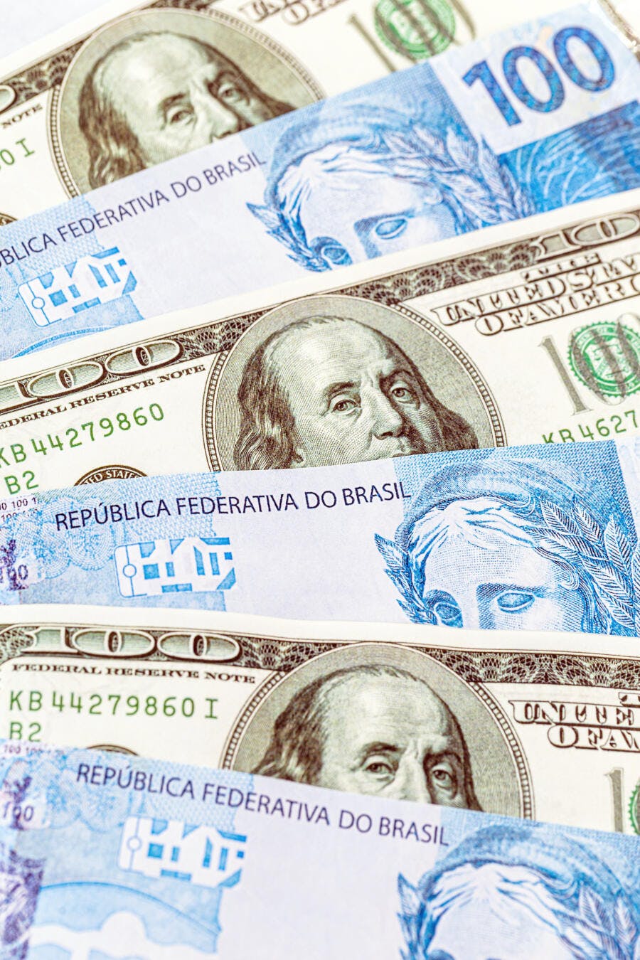 Cédulas de dólar americano e real brasileiro empilhadas mostrando economia global