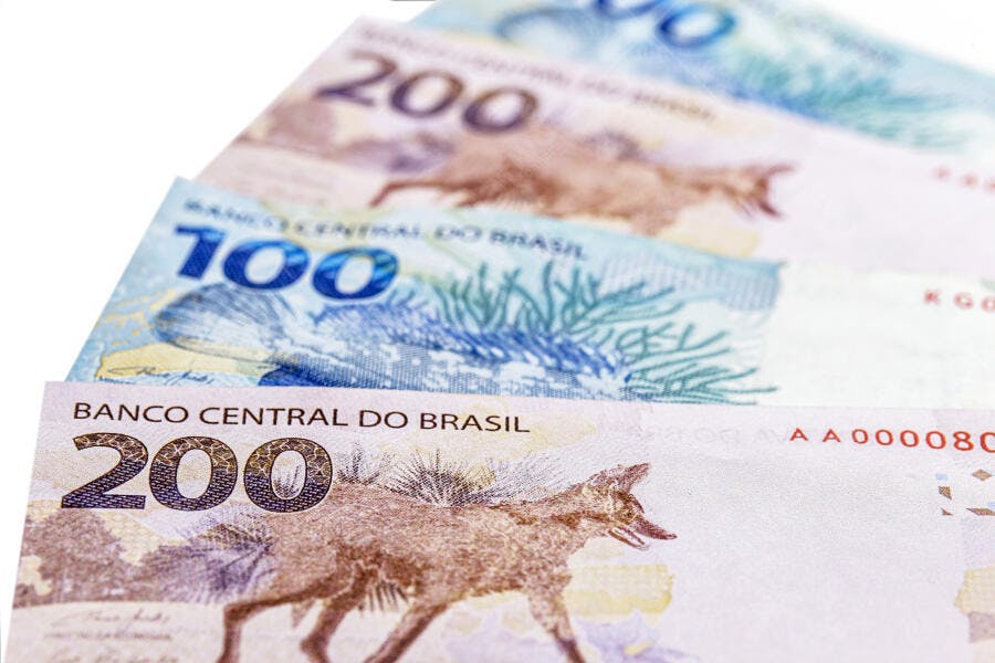 Notas de Real brasileiro de 100 e 200 reais com lobo-guará e garoupa em fundo branco