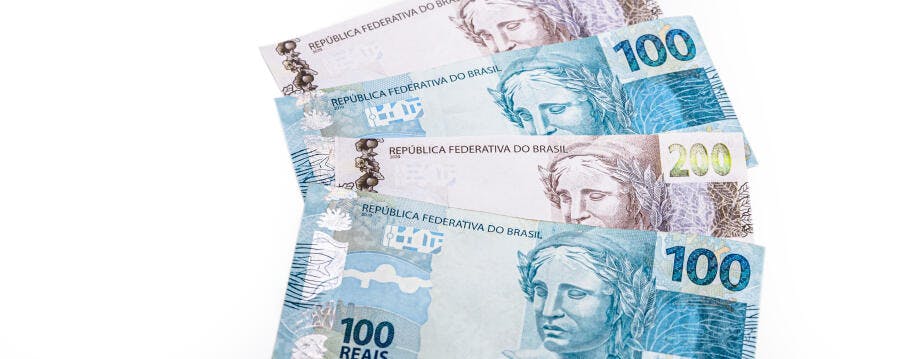 Cédulas de Real brasileiro de 100 e 200 reais em tons azuis cinzas sobre fundo branco