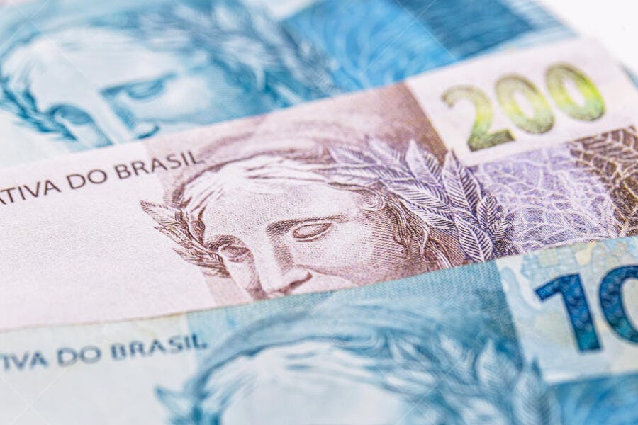 Notas de Real brasileiro R$ 200 e R$ 10 em close-up azul roxo