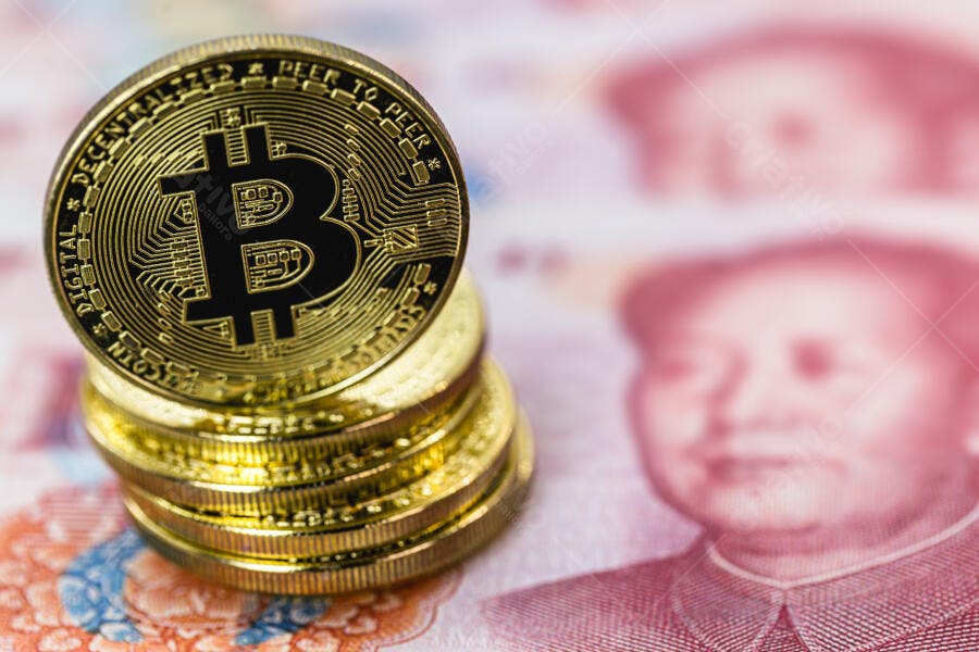 Bitcoin dourado empilhado sobre cédulas de Yuan chinês no mercado financeiro