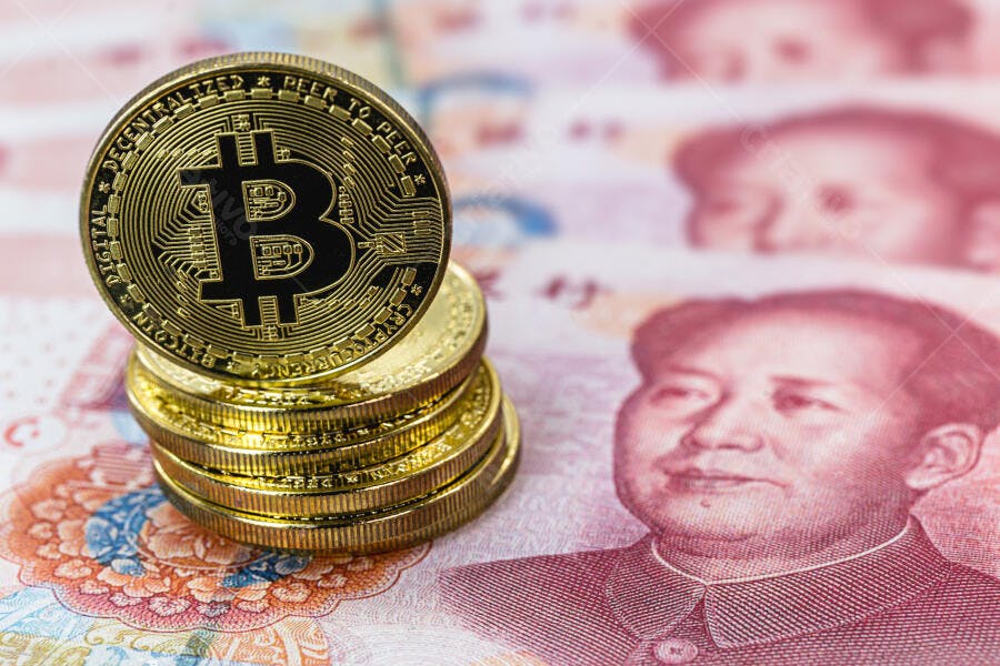 Criptomoeda Bitcoin dourada empilhada sobre notas vermelhas de Yuan chinês