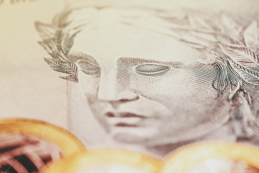 Dinheiro brasileiro nota de Real e moedas douradas em closeup