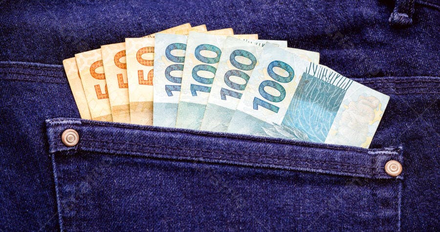Notas de real brasileiro em bolso de calça jeans azul escura