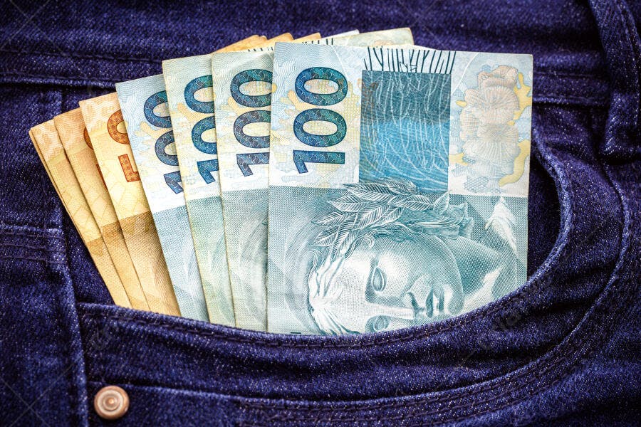Cédulas de Real brasileiro no bolso de calça jeans azul escura