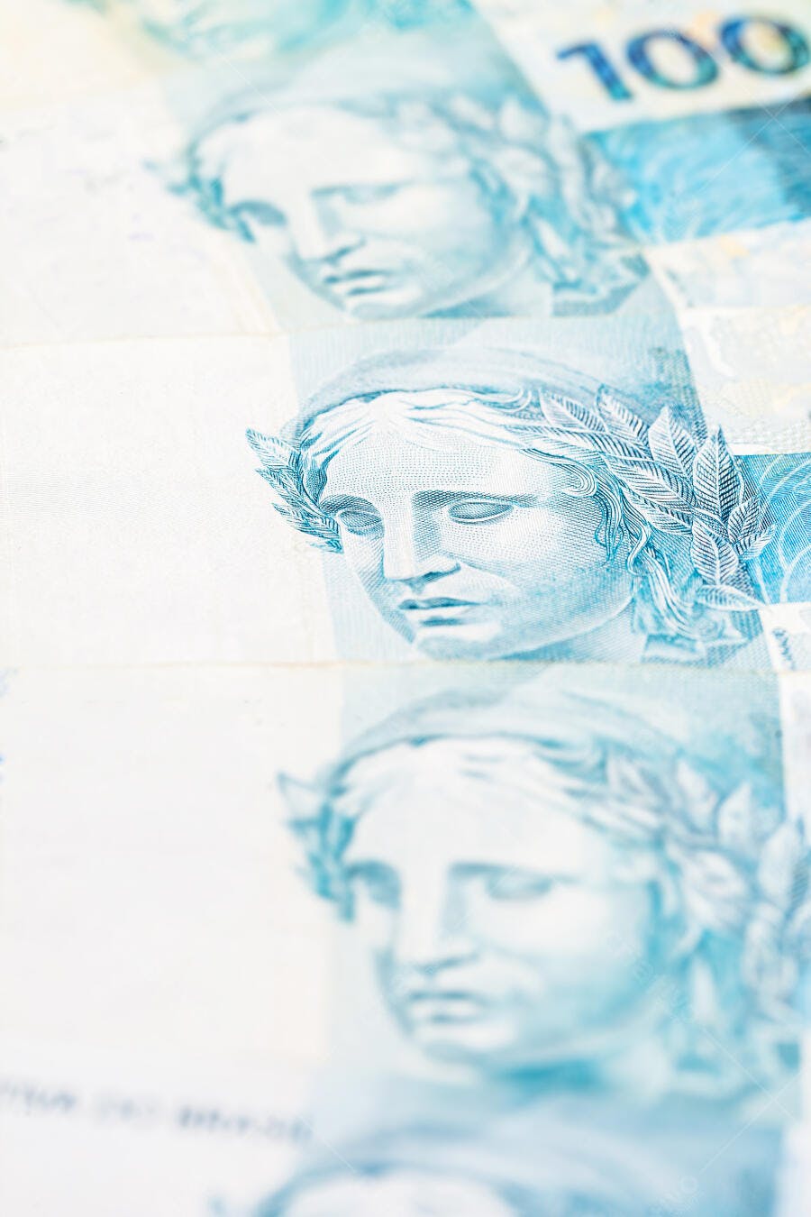 Notas de cem reais azuis e brancas com a Efigie da República em macro