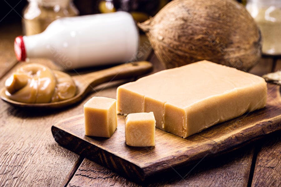 Doce de leite artesanal em barra e cremoso com coco na tábua de madeira